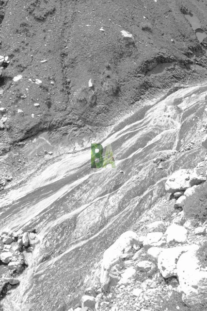 Coulée grise d'eau de fonte des neiges dans un vallons de marnes des alpes du sud